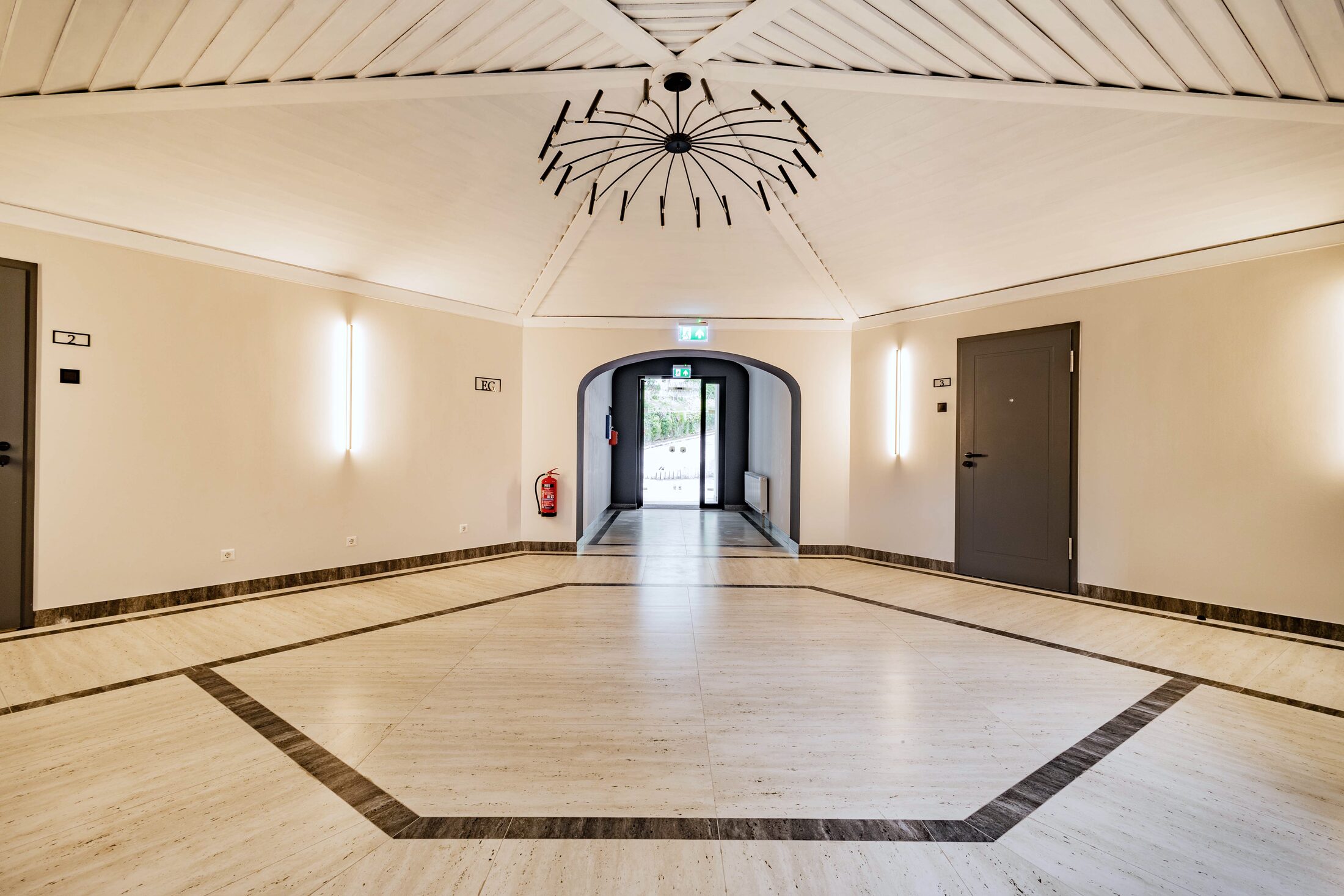 Heller Saal mit Kronleuchter und Parkett